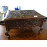 A carved oak casket with paper label inside 'the casket was carved by a Belgian refugee at Spaulding