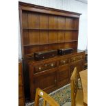 A Georgian oak farmhouse dresser, two parts, the upper section with two shelves and wide back walls,