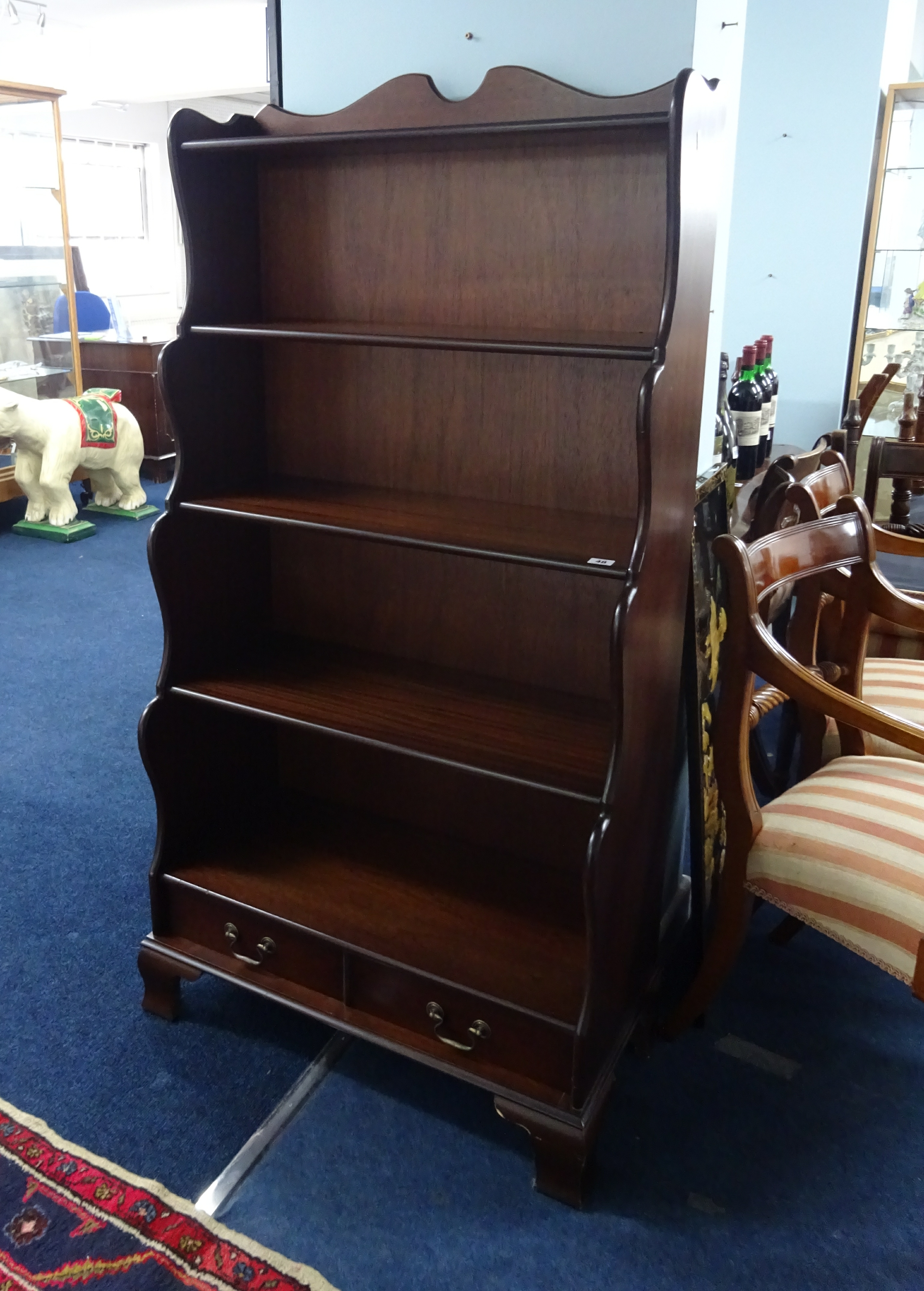 A reproduction mahogany 'waterfall' bookcase fitted with two drawers, width 77cm height 150cm.