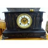 A Victorian black iron mantle clock decorated with rams head with 8 day movement.