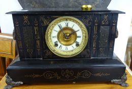 A Victorian black iron mantle clock decorated with rams head with 8 day movement.