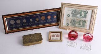 A Great War 'Mary' tin, a Caithness paperweight, two Bank of England £1 Notes, a sterling coin