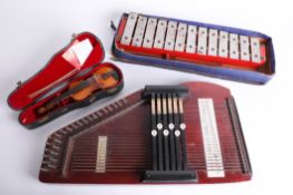 A cased miniature violin, a xylophone and an autoharp.
