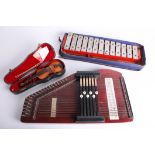 A cased miniature violin, a xylophone and an autoharp.