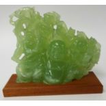 A carved 'jade' group depicting Buddha and laughing monkeys, height 18cm, width 22cm on later