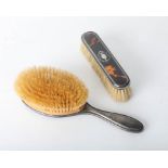 Two tortoiseshell and silver back dressing table brushes.