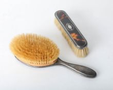 Two tortoiseshell and silver back dressing table brushes.