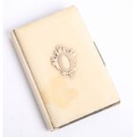 A vintage pocket notebook with ivory cover.