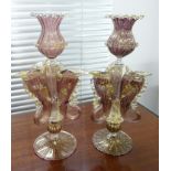 A pair of Venetian fish emblem glass candlesticks, decorated in purple with gold flecks, height