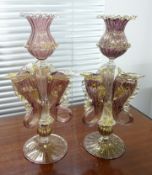 A pair of Venetian fish emblem glass candlesticks, decorated in purple with gold flecks, height