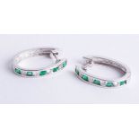 A pair 14ct white gold diamond and emerald hoop earrings.