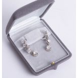 A fine pair of diamond drop earrings, each comprising four graduated diamonds, the largest approx