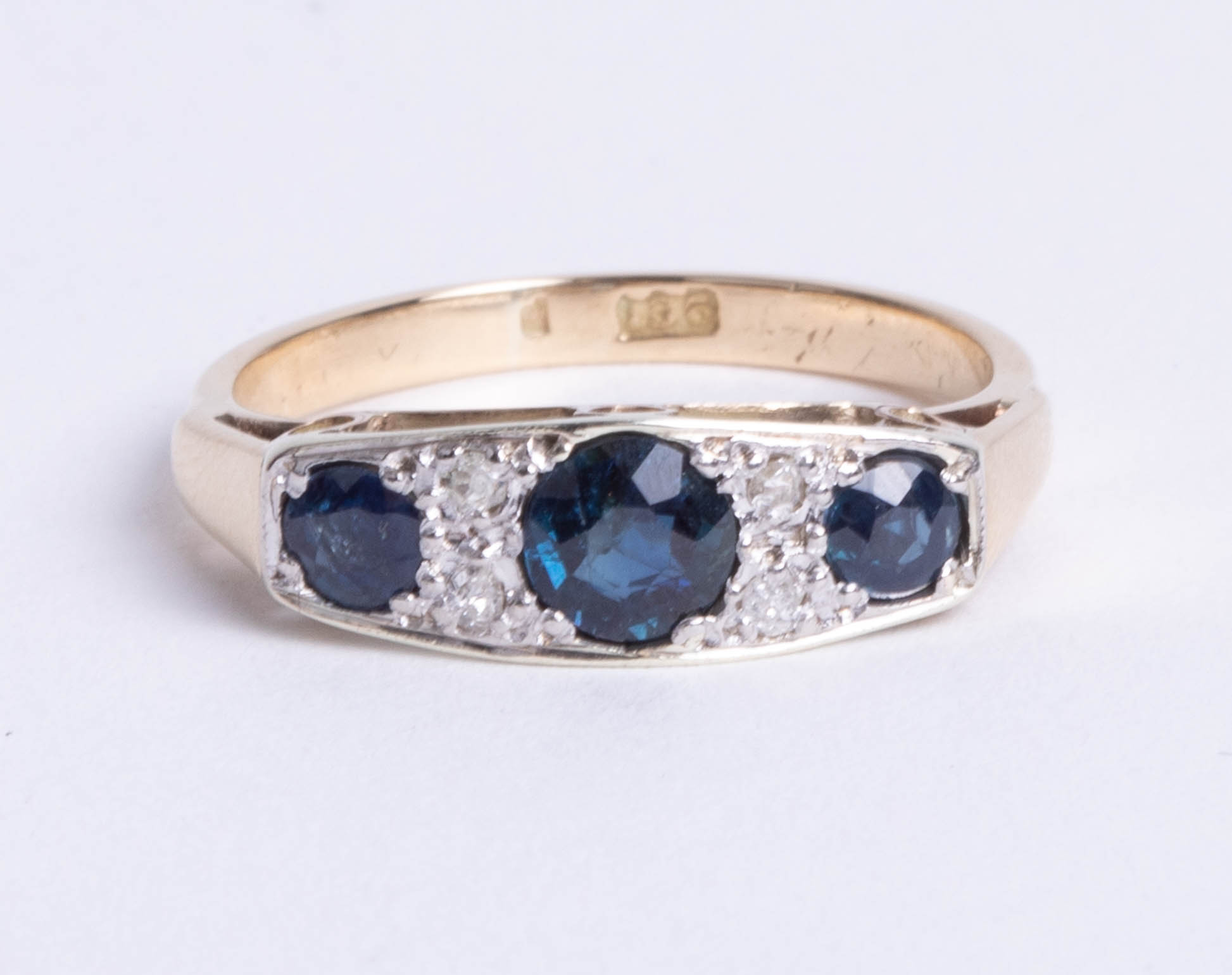 A 9ct gold and platinum seven stone ring, comprising three graduated round cut sapphires, divided