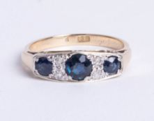 A 9ct gold and platinum seven stone ring, comprising three graduated round cut sapphires, divided