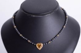 A gold and citrine set heart necklace.