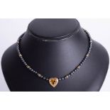 A gold and citrine set heart necklace.