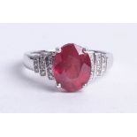 A 14k white gold and diamond ring set with an oval cut red gemstone approx 4.32 carats, diamonds