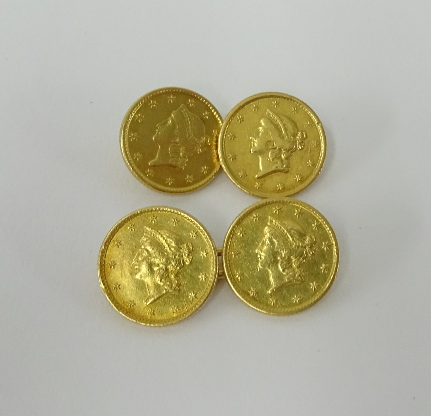 A pair of gold cufflinks set with four 1853 US dollar coins, approx. 7.70g.