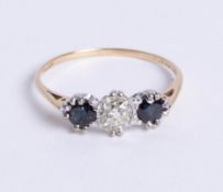 A 9ct gold three stone ring, comprising central old cut diamond with one round cut sapphire set
