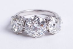 A fine large graduated diamond three stone ring, set with three old brilliant cut diamonds, centre