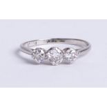 A platinum and diamond set three stone ring, size M.