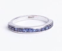 An 18ct white gold eternity ring, set with 14 square cut sapphires, size M.