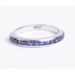 An 18ct white gold eternity ring, set with 14 square cut sapphires, size M.