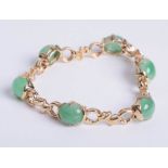 A 14kt yellow gold jade bracelet, compriisng six oval cut matched quality jade divided by fancy
