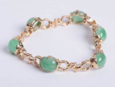 A 14kt yellow gold jade bracelet, compriisng six oval cut matched quality jade divided by fancy