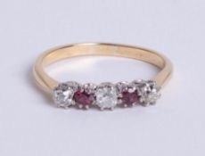 An 18ct yellow gold five stone ring, comprising three old cut diamonds, divided by two round cut