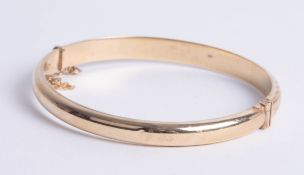 A 9ct gold bangle, makers mark 'DLM', approx 8.80g.