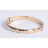 A 9ct gold bangle, makers mark 'DLM', approx 8.80g.