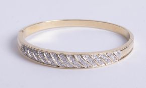 A 9ct yellow gold hinged bangle, pavé set diamond top section with graduated gold bars, box snap