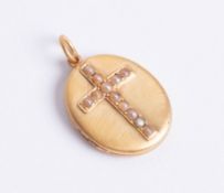 Oval antique locket. 15ct gold brushed finished with seed pearl set cross to front.