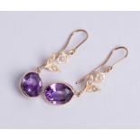 A pair of 9ct yellow gold amethyst and pearl drop earrings, each comprising an oval cut amethyst