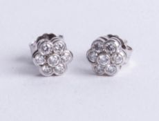 A pair of platinum and diamond set cluster earrings, diameter 6mm.