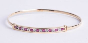 A 14ct ruby and diamond set bangle, 5.40g.