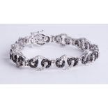 A contemporary white gold black and white diamond bracelet, length 19cm.