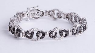 A contemporary white gold black and white diamond bracelet, length 19cm.