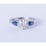 A platinum trilogy ring comprising a central brilliant cut diamond flanked on each side by royal