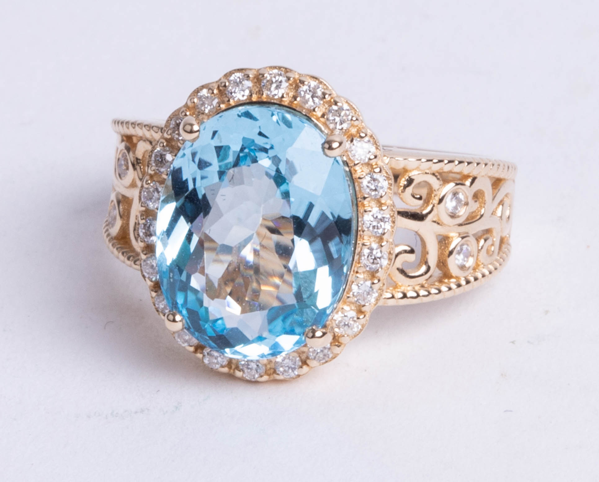 A 14k yellow gold and diamond ring set with an oval cut blue topaz, approx 5.92 carats, diamonds