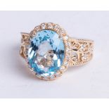 A 14k yellow gold and diamond ring set with an oval cut blue topaz, approx 5.92 carats, diamonds