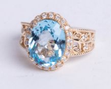 A 14k yellow gold and diamond ring set with an oval cut blue topaz, approx 5.92 carats, diamonds