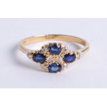 An 18ct yellow gold cluster ring set with four sapphires and diamonds, size T.