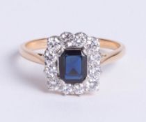 18ct gold rectangular cluster ring, comprising central emerald-cut sapphire surrounded by twelve