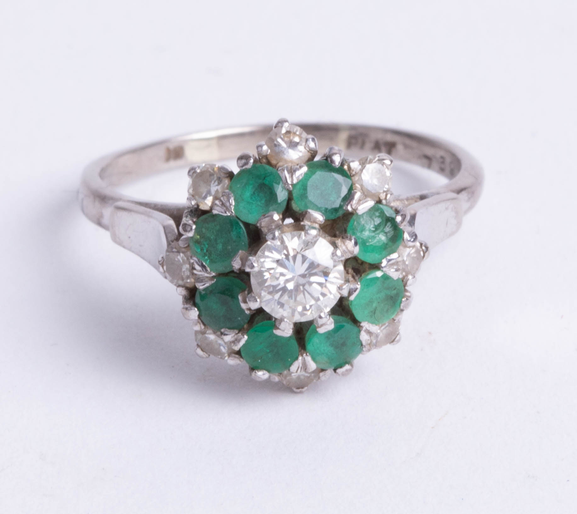 A platinum and 18ct gold diamond and emerald cluster ring, size O.