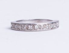 An unmarked white gold 11 stone diamond half eternity ring, size K.