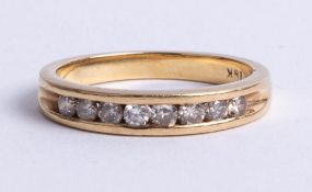 An 18k yellow gold and diamond channel half eternity ring, set with brilliant cut diamonds, approx