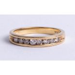 An 18k yellow gold and diamond channel half eternity ring, set with brilliant cut diamonds, approx