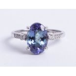 An 14k tanzanite and diamond mixed colour ring, size N.